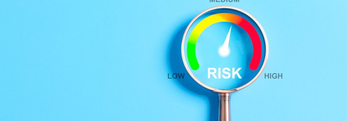 Magnifying glass highlighting a risk gauge with levels from low to high—needle pointing to medium risk. Visual concept representing audit readiness in financial aid operations.